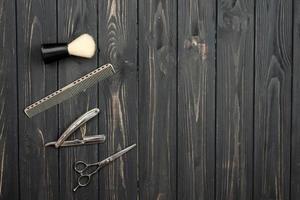 Herramientas de afeitado sobre fondo de madera oscura, espacio de copia foto