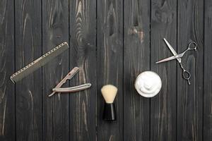 accesorios de afeitado sobre un fondo de textura de madera. instrumentos. afeitado, cepillo, maquinilla de afeitar con peligro de espuma.