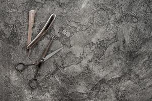 On a gray, plaster background is razor and scissors. photo