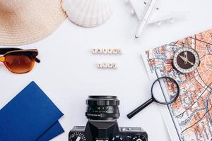 White background with things for travel passport, sunglasses, magnifying glass, hood, compass, seashell photo