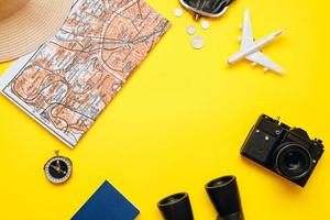 preparación para viajar, dinero, pasaporte, avión, sombrero, binoculares, cámara, mapa, sobre fondo blanco. foto