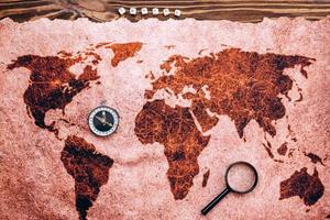Vacation planning concept. On the map of the world is a magnifying glass, a compass, the word travel is laid out from dice photo