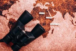 Black binoculars lies on the a geographical map photo