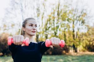 Young sporty woman is working out outdoor. photo