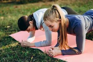 Photo of two adorable girls doing exercises outdoors. Sports strap