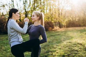 dos amigas realizan ejercicios cara a cara en la naturaleza. foto