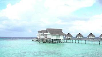 playa tropical y mar con bungalow en maldivas