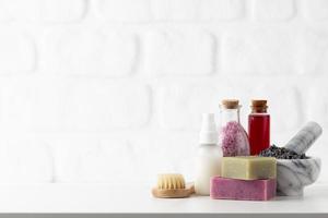 Cosmetics bottles and natural handmade soap on white background photo