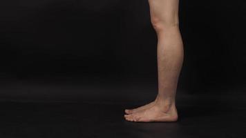 Asian Male legs and barefoot is isolated on black background