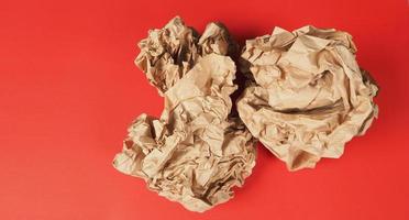 Crumpled brown papers.It is mauled on red background. photo