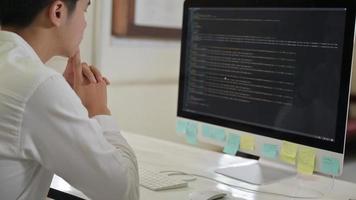 Programmer checks the code on a computer with a stressful expression. photo