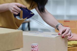 The seller is packing boxes to prepare for shipping. photo