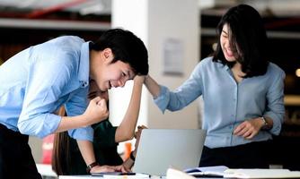 un hombre y una mujer usan una computadora portátil para revisar la bolsa de valores y mostrar alegría. foto