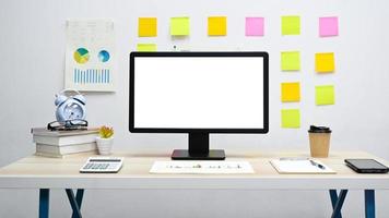 escritorio de oficina, computadora de pantalla en blanco con gráfico, calculadora, teléfono inteligente en el escritorio. foto