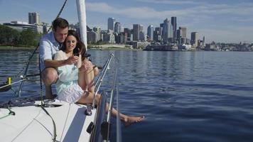 jeune couple sur voilier ensemble à l'aide de téléphone portable. tourné sur red epic pour une résolution 4k, uhd, ultra hd de haute qualité. video