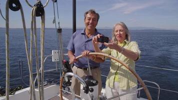 älteres Paar hinter dem Steuer des Segelbootes zusammen. Aufnahme auf rotem Epos für hochwertige 4k-, UHD- und Ultra-HD-Auflösung.