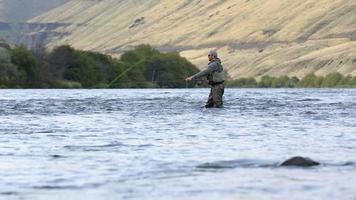 Man fly fishing in river video