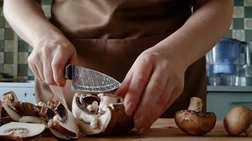 mulher prepara cogumelos na cozinha de casa. video