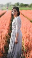 mujer asiática feliz caminando y tomando fotografías en el jardín de flores. foto