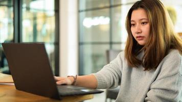 Adolescente asiática que usa la computadora portátil en el escritorio, aprendizaje en línea, video chat. foto