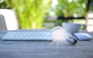 Idea innovation and inspiration concept. illuminated light bulb on table, concept photo