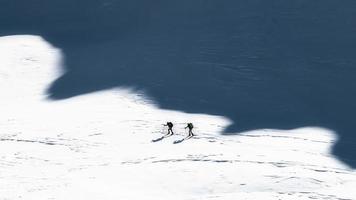 Ski mountaineers in the shadows of the mountains. Artistic style photo