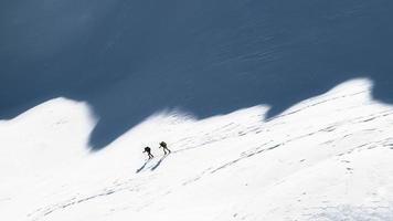 montañeros de esquí en las sombras de las montañas foto