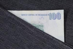 Nicaraguan banknote of 100 cordobas between blue denim fabric