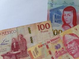 Aproximación a los billetes mexicanos de 100 pesos y fondo blanco.