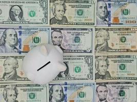 White piggy bank and background with american dollar bills, view from above photo