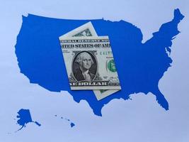 Billete de un dólar americano y fondo con silueta de mapa de Estados Unidos foto