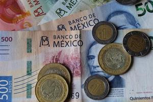 Aproximación a la moneda mexicana y los billetes de diferente denominación. foto