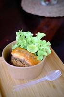 Fried salmon steak with red rice and vegetables on wooden table photo