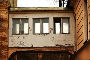 Tres viejas ventanas oxidadas en el corredor blanco de edificios puente