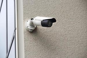 Outdoor video security camera on concrete wall on building corner photo