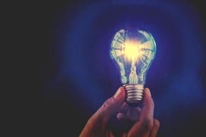 Bulb with lighting. Idea and Creative concept  for startup new project. Technology object and Electrical part theme. Energy and Power saving theme. Copy space in the left side. Blue filter background photo