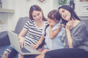 Family with mother and kid having time together lerning with using laptop computer. photo