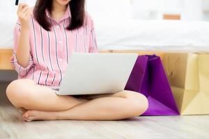 Closeup asian woman shopping online with laptop computer. photo