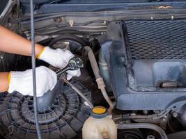 Mechanic holding a block wrench handle while fixing a car. photo