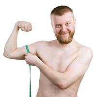 Bearded man measures his little biceps
