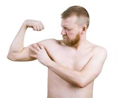 Bearded man measures the his biceps photo