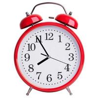 Red round clock shows five minutes to eight photo