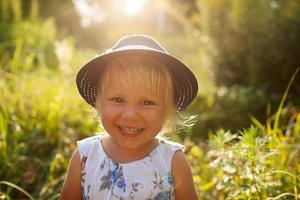Little blonde girl in a blue hat photo
