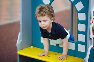 niño pequeño está jugando en el patio de recreo foto