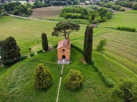 Drone view of freshly married couple at the red church of Pomelasca photo