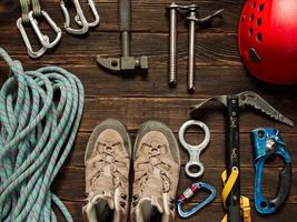 Climbing equipment on dark wooden background, top view photo