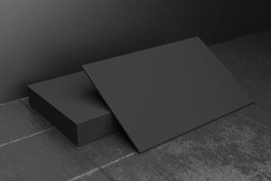Black horizontal business card paper mockup template with blank space cover for insert company logo or personal identity on black concrete floor background. Modern concept. 3D illustration render photo