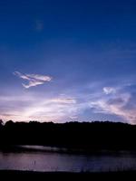 Beautiful sky landscape with sunset over river bank photo