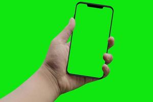 moderno teléfono inteligente en la mano. pantalla verde y fondo foto