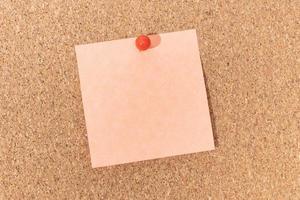 Blank note and push pin on cork board. Template to ad text or drawings photo